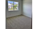 Cozy bedroom with neutral carpet, white walls, and a window offering a neighborhood view at 1646 Pinecliff Dr, Apopka, FL 32703