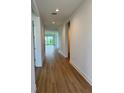 Bright hallway with wood-look flooring and neutral walls leading to other rooms at 1646 Pinecliff Dr, Apopka, FL 32703