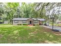 Inviting single-story home with a well-maintained lawn, mature trees providing ample shade, and a cozy front porch at 1753 Nw 44Th St, Ocala, FL 34475