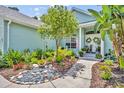 Front entrance showcasing a stone walkway and lush flower beds at 195 River Village Drive, Debary, FL 32713