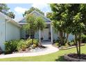 Charming single-story home with a beautifully landscaped yard and a welcoming walkway to the front door at 195 River Village Drive, Debary, FL 32713
