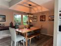 Cozy dining room featuring wood floors, a rustic table, and modern light fixture at 200 Hummingbird Ln, Longwood, FL 32779
