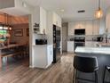 Bright modern kitchen with white cabinets, stainless steel appliances, an island, and wood floors at 200 Hummingbird Ln, Longwood, FL 32779