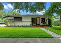 Inviting home showcasing a well-maintained lawn and an appealing facade with cozy front porch seating at 2190 Temple Dr, Winter Park, FL 32789