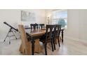 Features a wooden dining table with black chairs and a telescope in a sunlit space at 2279 Mountain Pine St, Ocoee, FL 34761