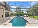 Relaxing screened-in pool area with lounge chairs and outdoor seating at 25537 High Hampton Cir, Sorrento, FL 32776