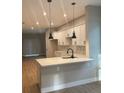 Modern kitchen featuring white cabinets, marble countertops, stainless steel appliances, and sleek pendant lighting at 317 Mandrake St, Orlando, FL 32811