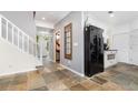 Hallway with tiled floors leading to a kitchen and living space with stairs on the left at 32125 Wekiva Pines Blvd, Sorrento, FL 32776