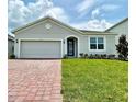 Lovely single-story home with brick paver driveway, arched entry and well-maintained lawn at 341 Switchgrass Loop, Minneola, FL 34715