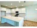 Bright, modern kitchen with a large island, stainless steel appliances, and white cabinetry at 341 Switchgrass Loop, Minneola, FL 34715