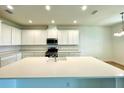 Spacious kitchen features a large center island, modern appliances, and ample white cabinetry at 341 Switchgrass Loop, Minneola, FL 34715