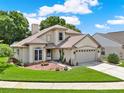 Beautiful exterior view of a cream-colored home with manicured landscaping and a spacious driveway at 3561 Ventura Club Cir, Orlando, FL 32822
