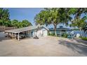 A blue house with a carport, basketball hoop and lake view at 36607 E Eldorado Lake Dr, Eustis, FL 32736