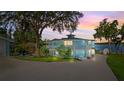 Stunning two-story home with a white railing balcony, and lakeside at sunset at 36607 E Eldorado Lake Dr, Eustis, FL 32736