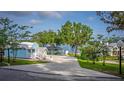 A spacious driveway with a two-story home with balcony and lake view at 36607 E Eldorado Lake Dr, Eustis, FL 32736