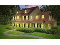 Stunning yellow two-story home featuring a charming wrap-around porch and verdant landscaping at 4200 Joslyn Ln, Lady Lake, FL 32159