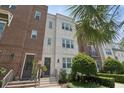 Inviting multi-story townhome featuring brick and white brick, with an entryway framed by manicured greenery at 464 W Plant St, Winter Garden, FL 34787