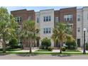 Attractive townhomes boasting brick and painted brick exteriors, enhanced by palm trees and well-manicured landscaping at 464 W Plant St, Winter Garden, FL 34787