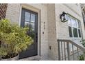 Close-up of the front door featuring a modern glass-paneled door, stylish exterior lantern, and manicured greenery at 464 W Plant St, Winter Garden, FL 34787