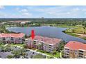 Waterfront condo building with red tile roof, tropical landscaping, and parking at 5024 Shoreway Loop # 10106, Orlando, FL 32819