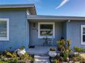 Inviting front porch with tiled floor, stylish plants, and outdoor furniture at 7033 Lakner Way, Orlando, FL 32822
