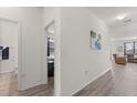 Bright hallway with wood floors leading to bedrooms, bathrooms, and living room at 756 Rioja Dr, Minneola, FL 34715