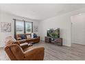 Bright living room offering wood floors, a large window, comfortable seating, and a modern entertainment center at 756 Rioja Dr, Minneola, FL 34715