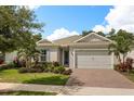 Charming one-story home boasts a pristine lawn, inviting walkway, and an attached two-car garage at 7778 Four Seasons Blvd, Kissimmee, FL 34747