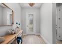 Bright foyer featuring wood-look tile flooring, stylish light fixture, and decorative console table at 7778 Four Seasons Blvd, Kissimmee, FL 34747