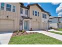 Charming townhome with neutral paint, attached garages, small yard and inviting blue front door at 832 Longboat Dr, Davenport, FL 33896