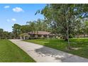 Lovely home with a long driveway, lush lawn, and mature landscaping creates inviting curb appeal at 9601 Ambleside Dr, Windermere, FL 34786