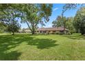 Expansive green lawn and shade trees surround this charming home, creating a serene outdoor space at 9601 Ambleside Dr, Windermere, FL 34786