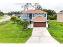Two-story home with a large front yard, driveway, and two-car garage at 1001 Dampierre Ct, Kissimmee, FL 34759