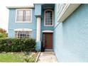 Home exterior showcases a light-blue exterior, lush bushes and a walkway at 1001 Dampierre Ct, Kissimmee, FL 34759