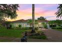 Exterior view of a charming home with a brick driveway and beautiful landscaping at sunset at 11015 Hawkshead Ct, Windermere, FL 34786
