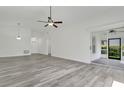 Bright living room featuring new flooring, a ceiling fan, and sliding door access at 1406 Sean Ct, St Cloud, FL 34772
