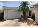 Single Gathering home featuring an attached garage, with a well-manicured lawn at 1524 Conway Ct, The Villages, FL 32162
