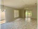 Spacious living room featuring wood-look floors, abundant natural light, and a ceiling fan at 1524 Conway Ct, The Villages, FL 32162