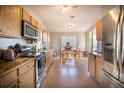 Eat-in kitchen features wooden cabinets, granite countertops, stainless steel appliances, and tile flooring at 1662 Canoe Creek Rd, Oviedo, FL 32766