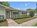 Charming home entrance features a brick walkway, manicured bushes, and covered porch at 2112 Fosgate Dr, Winter Park, FL 32789