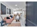 Open-concept living room with modern décor, light gray walls, hardwood floors and kitchen view at 23430 Sw Neptune Blvd, Dunnellon, FL 34431