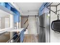 Well-equipped kitchen with stainless steel appliances, wood floors, and a barn door to the stairway at 244 N Leavitt Ave, Orange City, FL 32763