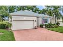 Charming one story home with brick driveway, manicured landscaping, and a two car garage at 2500 Castle Pines St, Clermont, FL 34711