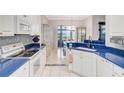Charming kitchen with white cabinetry, blue countertops, and stainless steel appliances at 2500 Castle Pines St, Clermont, FL 34711