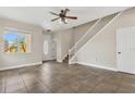 Bright living room featuring tile floors and stairs, with a front door leading to the outside at 3009 Park Ridge Ave, Mulberry, FL 33860