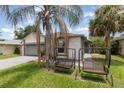 Charming single Gathering home featuring an attached garage, palm tree and landscaped yard at 3280 Pinto Dr, Kissimmee, FL 34746