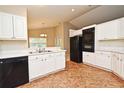 Efficient kitchen with white cabinets, black appliances, and eat-in area at 33042 Lake Bend Cir, Leesburg, FL 34788