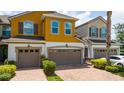 Two-story townhouse featuring an attached garage and a brick paved driveway at 3508 Brighton Park Cir, Belle Isle, FL 32812