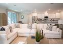 Living room featuring a large sofa that opens into a modern kitchen and breakfast area at 351 S Sunset Ave, Mascotte, FL 34753