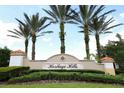Elegant community sign for Heritage Hills, framed by lush greenery and palm trees, welcoming residents and visitors at 3574 La Jolla Dr, Clermont, FL 34711